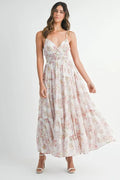 A flowy floral print tiered maxi dress with cami straps in white and pink.
