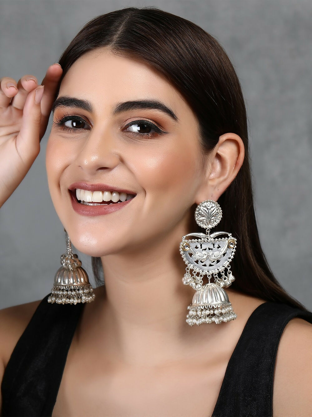 Silver tone ghungroo jhumka earrings with intricate patterns and sparkling stone accents