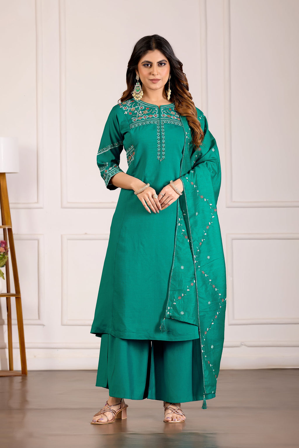 A teal viscose mango silk kurta with multi-colored thread embroidery and hand work paired with matching palazzo pants.