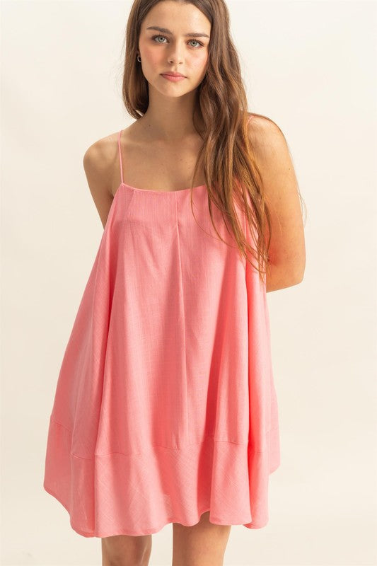 A breezy linen A-line mini cami dress with pockets in coral and pink.