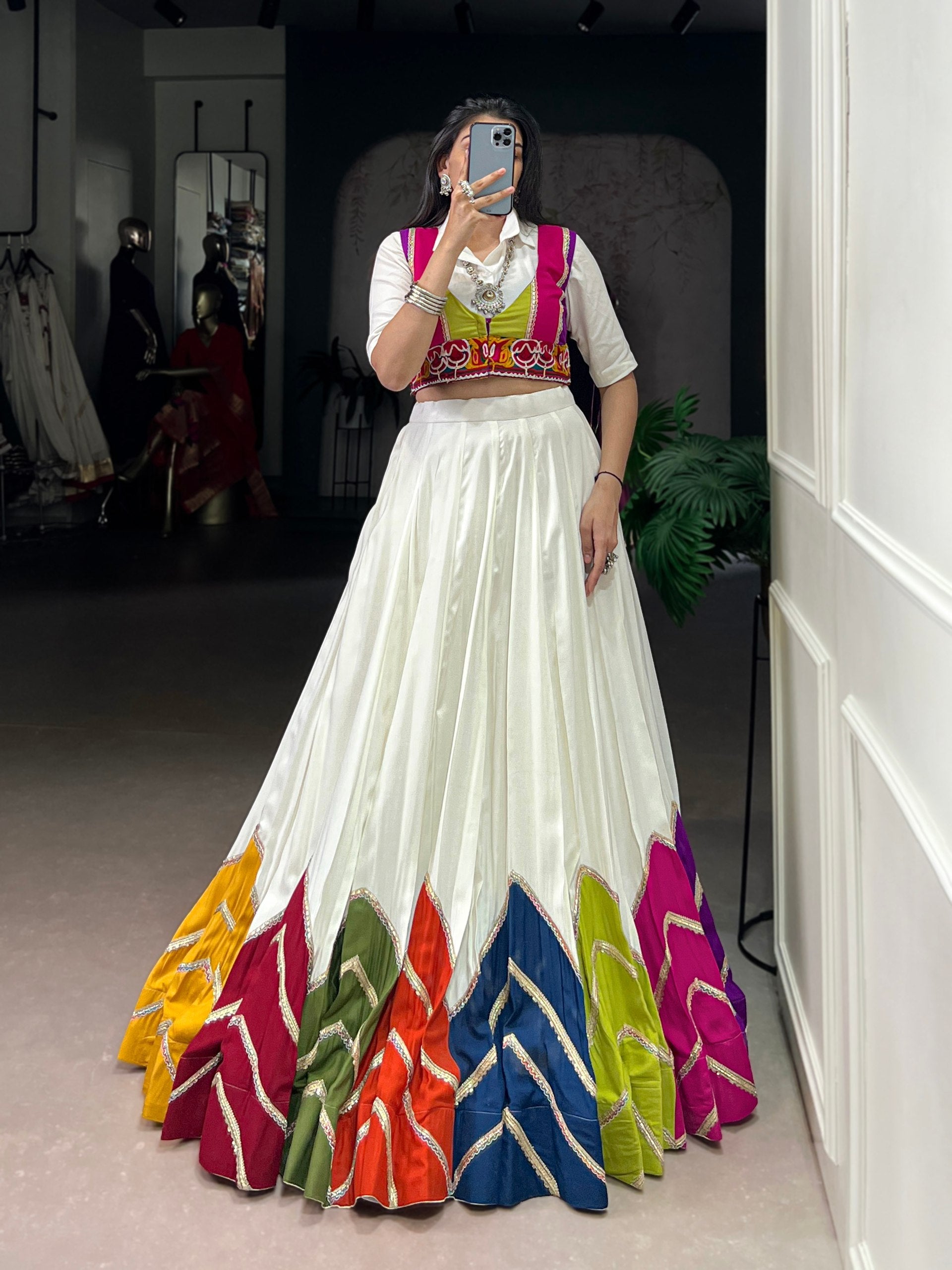 Woman wearing a white rayon lehenga choli with multi-colour patch work and lace details for Navratri.