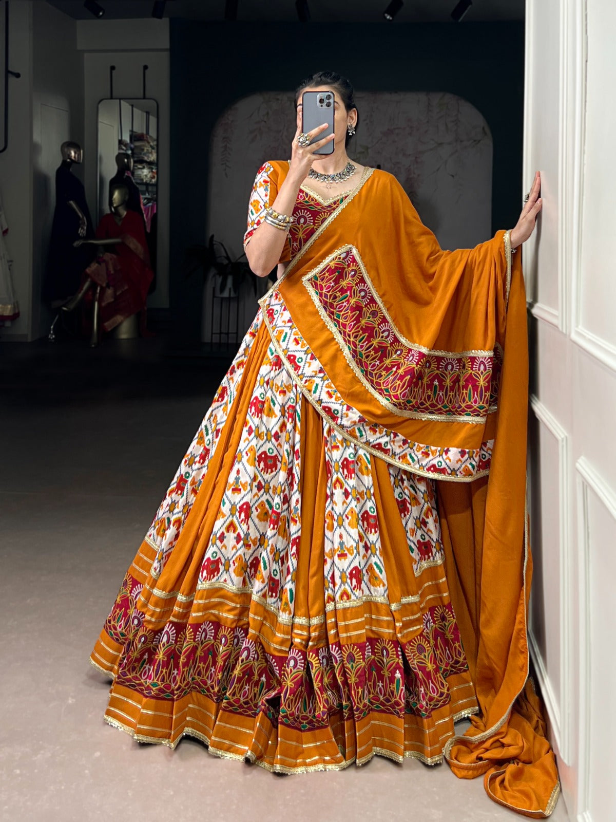 Mustard yellow lehenga choli with Patola print, Gamthi work detailing, and a matching dupatta