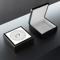 Modern wooden jewelry box with a glossy ceramic inlay and soft felt interior on a clean vanity surface.