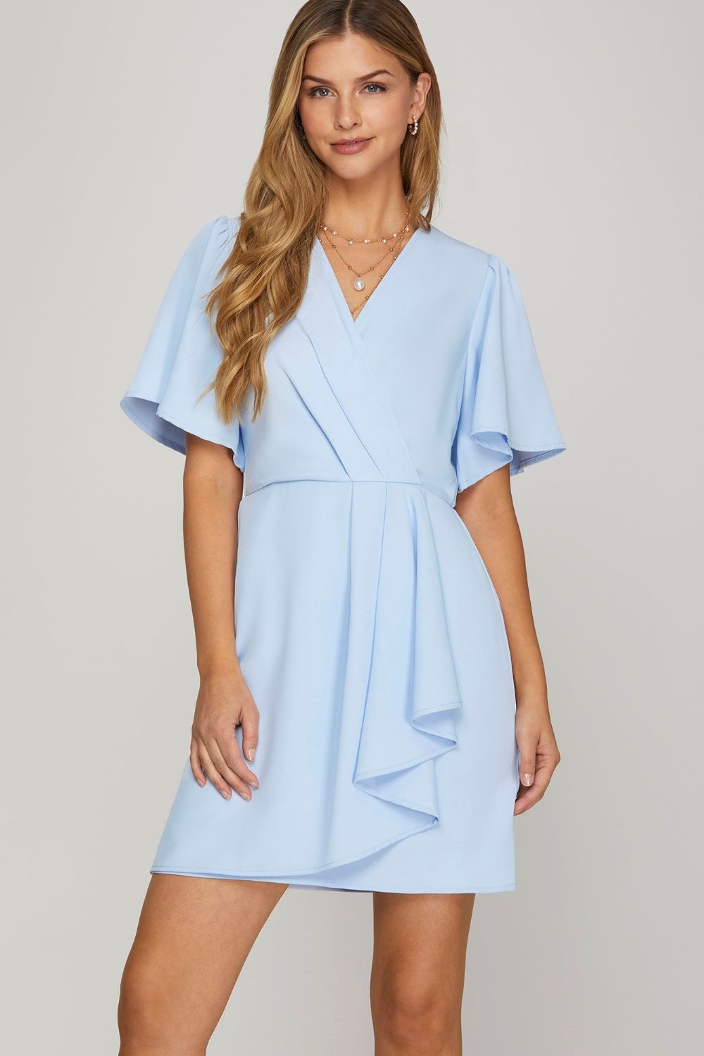 Feminine mini dress with surplice neckline, ruffles, and flutter sleeves
