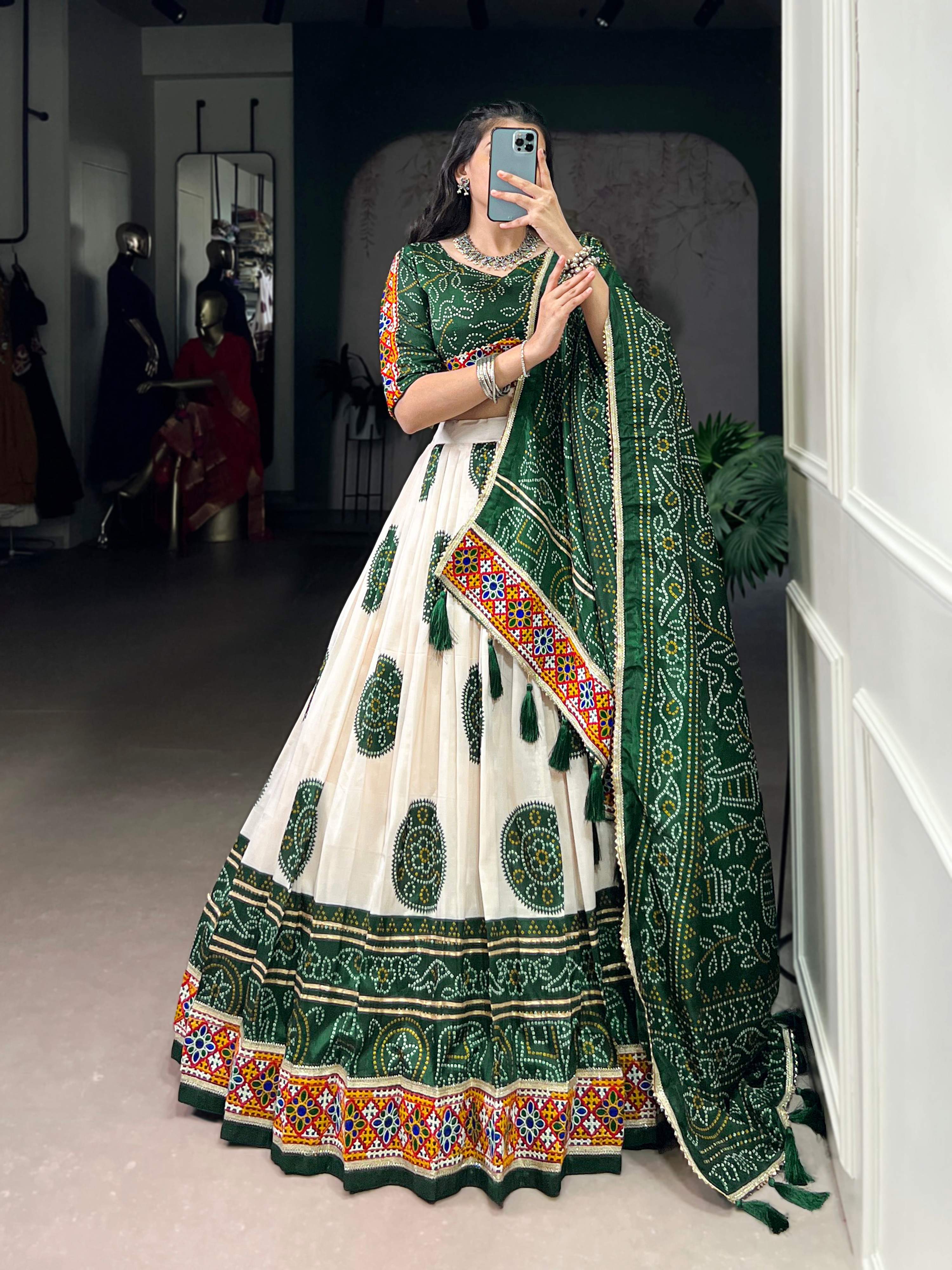 Off-white Tasar silk lehenga with dark green geometric Bandhej and intricate Gamthi work.