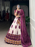 Woman wearing an off-white Tasar silk lehenga with plum-purple Bandhej print and Gamthi work.