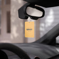 Minimalist mustard yellow and black car air freshener hanging in a modern car interior.