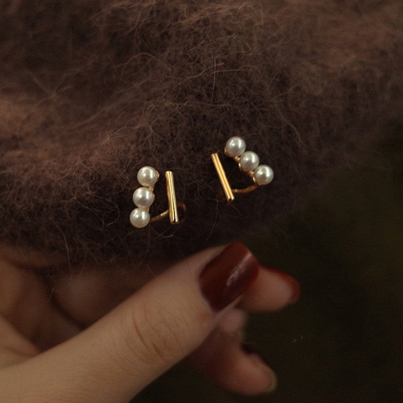 Close up of gold-plated mini heart studs featuring a polished, chic design.