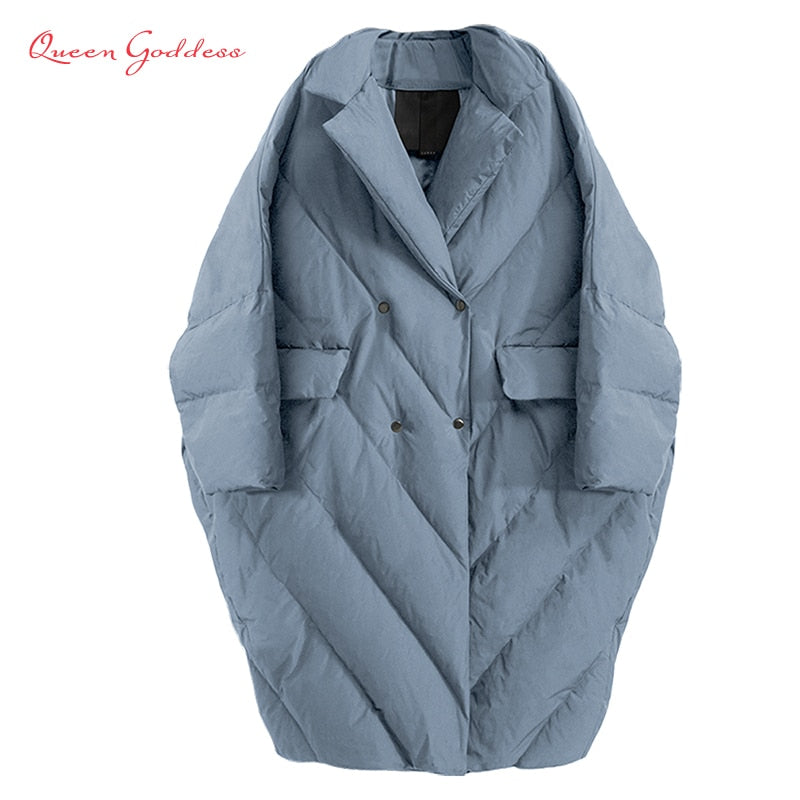 Model wearing an oversized slate blue quilted long down coat with a lapel collar, showcasing its voluminous fit and cozy design.