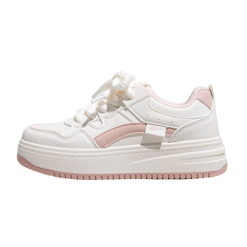 A pair of trendy white platform sneakers with pink color block accents and thick rubber soles.