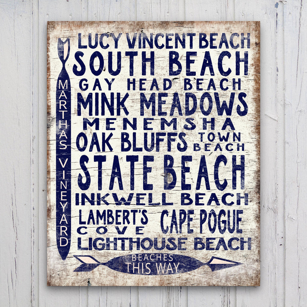 Vintage wood arrow sign featuring Martha's Vineyard beach locations in navy blue on a distressed white background.