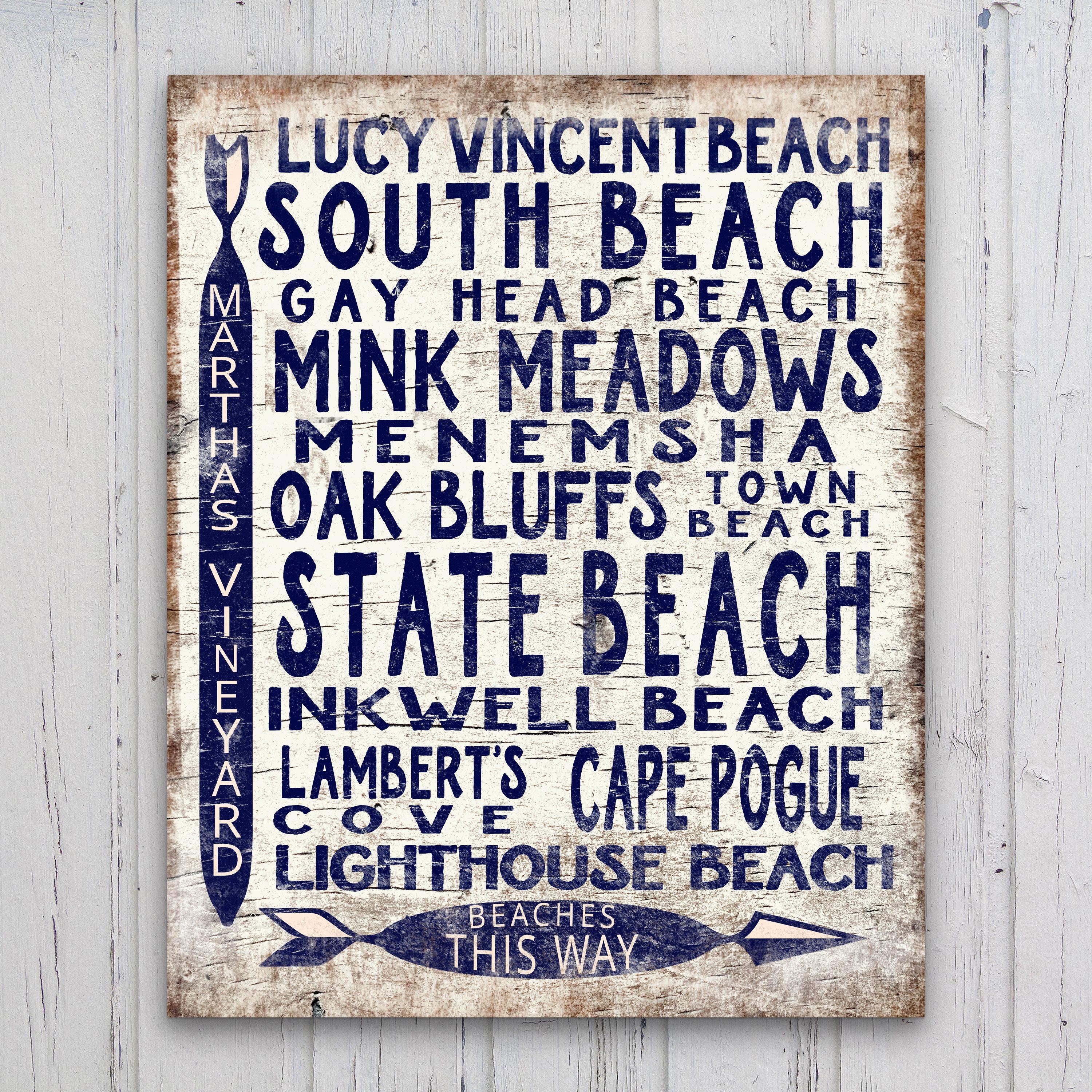 Vintage wood arrow sign featuring Martha's Vineyard beach locations in navy blue on a distressed white background.