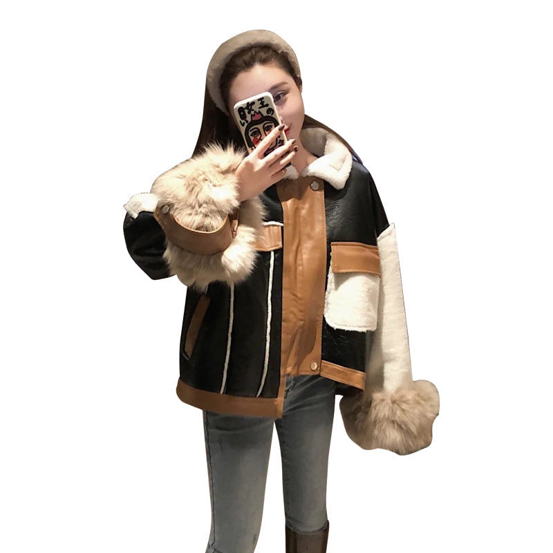 A woman wearing a black, brown, and white color block faux leather jacket with faux fur trim on the collar, cuffs, and hem, styled in a Harajuku-inspired outfit.