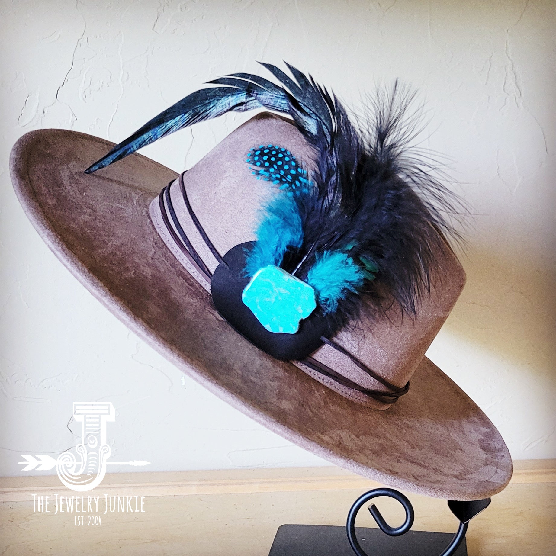 Western felt hat accessorized with a marabou blue spotted feather and turquoise slab leather hat band