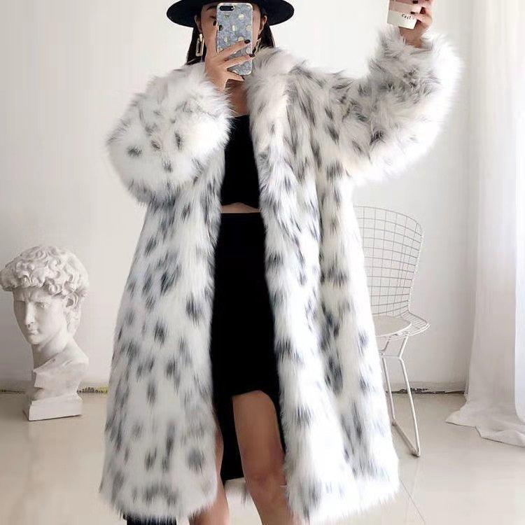 A woman wearing a long white and black leopard print faux fur jacket with a lapel collar.