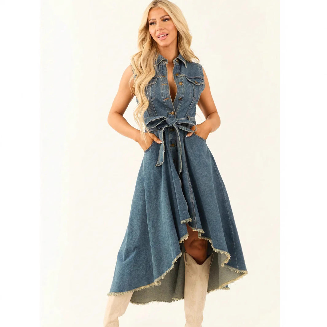 Model wearing a sleeveless medium-blue denim midi dress with an irregular hem and button-front