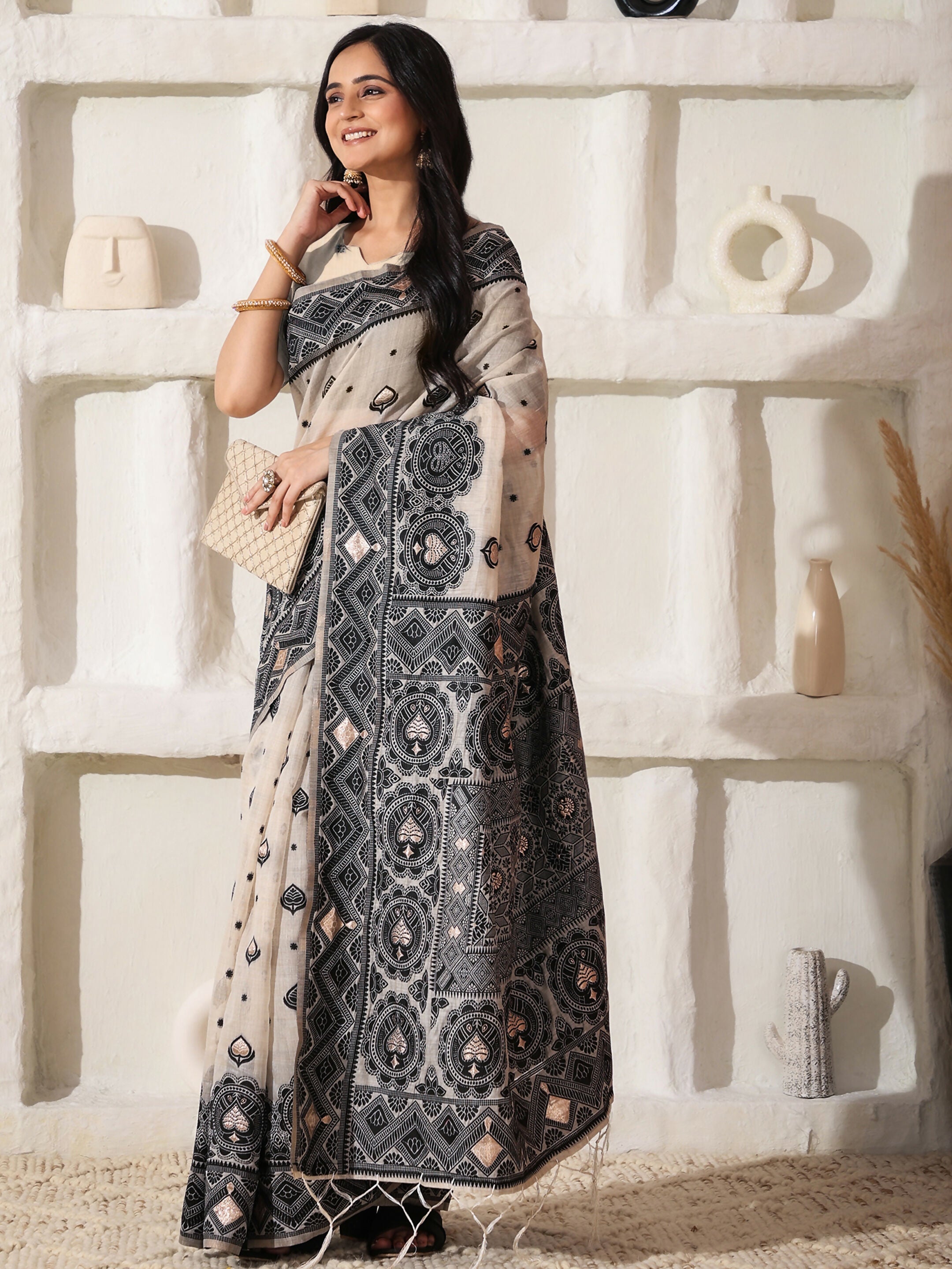 Elegant black and cream linen cotton saree with a matching cream blouse.