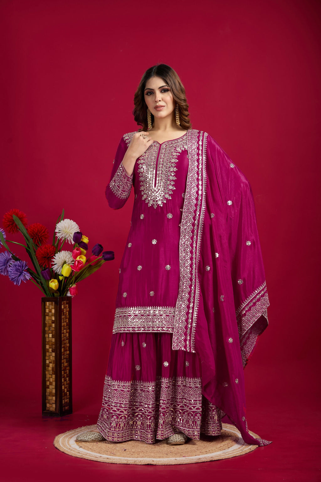 A luxurious Rani-colored silk kurta set with detailed sequins, zari, and thread embroidery.