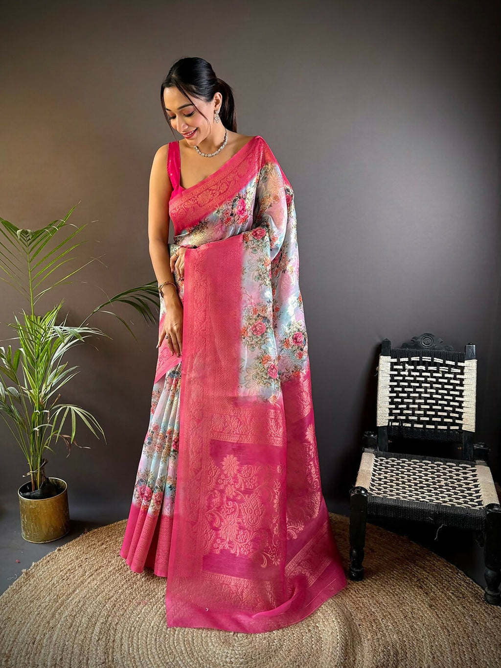 Pink Banarasi silk saree with detailed floral motifs and accompanying unstitched blouse piece