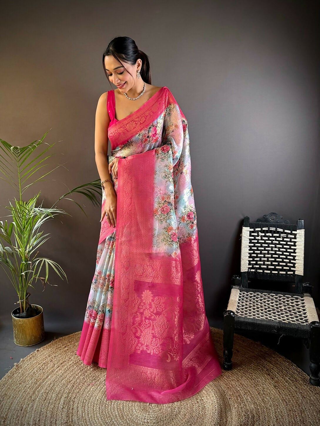 Pink Banarasi silk saree with detailed floral motifs and accompanying unstitched blouse piece
