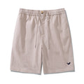 Men wearing relaxed fit flax beige linen Bermuda shorts with mid-rise and zip-fly closure.