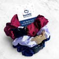 A 3-pack of satin buckle scrunchies in red, white, and blue colors.