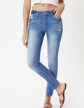 Model wearing Mendy mid-rise super skinny jeans in medium indigo blue with subtle whiskering