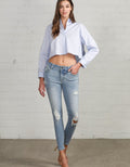 Woman wearing mid-rise ankle skinny jeans in blue denim with a slim-fit silhouette.