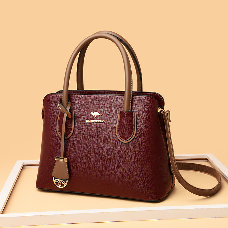Spacious leather-style parent tote bag with removable crossbody strap in a neutral design.