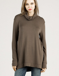 A woman wearing a comfortable dark olive loose fit bamboo turtle neck top