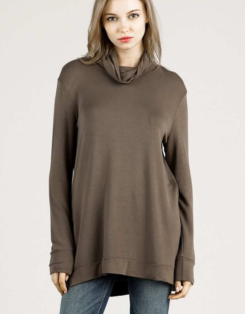 A woman wearing a comfortable dark olive loose fit bamboo turtle neck top