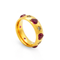A close-up of a brilliant gold XOXO Love Ring featuring inlaid heart-shaped ruby gemstones and star-shaped diamonds, shown on a clean white background.