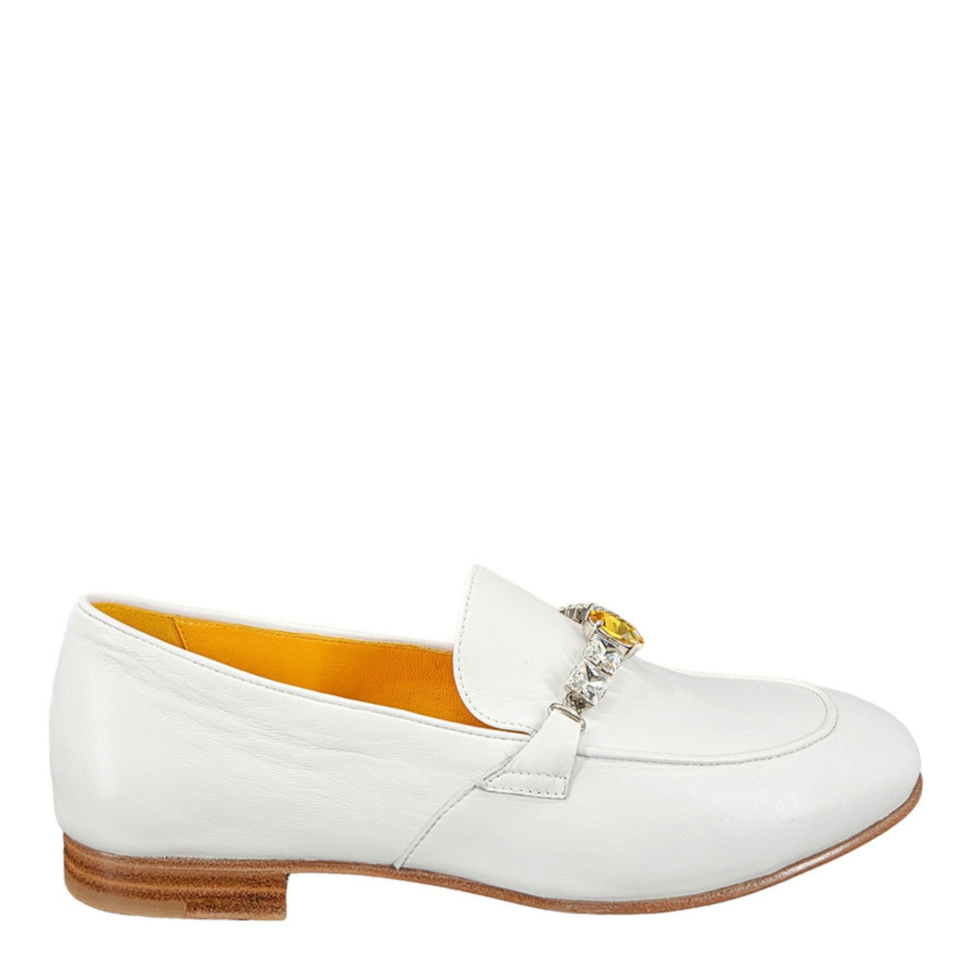 Side view of a white leather flat loafer adorned with a row of clear and yellow crystal embellishments on a white background.