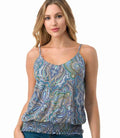 Woman wearing a relaxed-fit sleeveless tank top with a multi-colored blue and brown abstract paisley print.