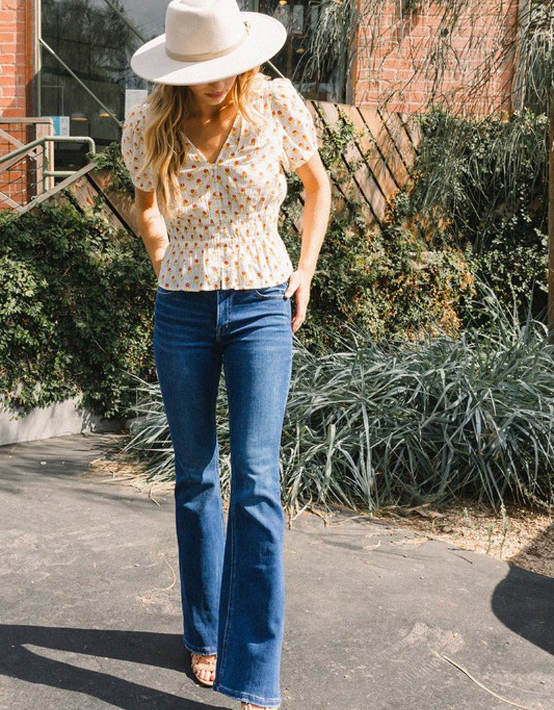 Woman wearing Alison Mid Rise Flare medium-blue denim jeans with a flared silhouette