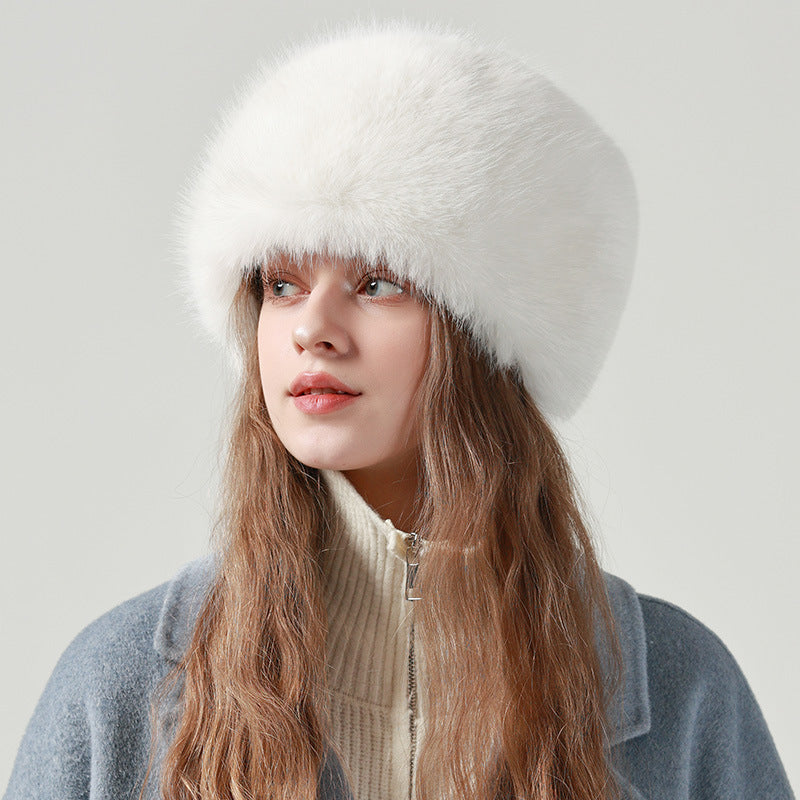 A woman wearing a white plush faux fur bucket hat, side view showing soft texture.