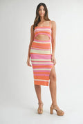 Model wearing a colorful orange pink and cream striped knit midi dress with front cutout