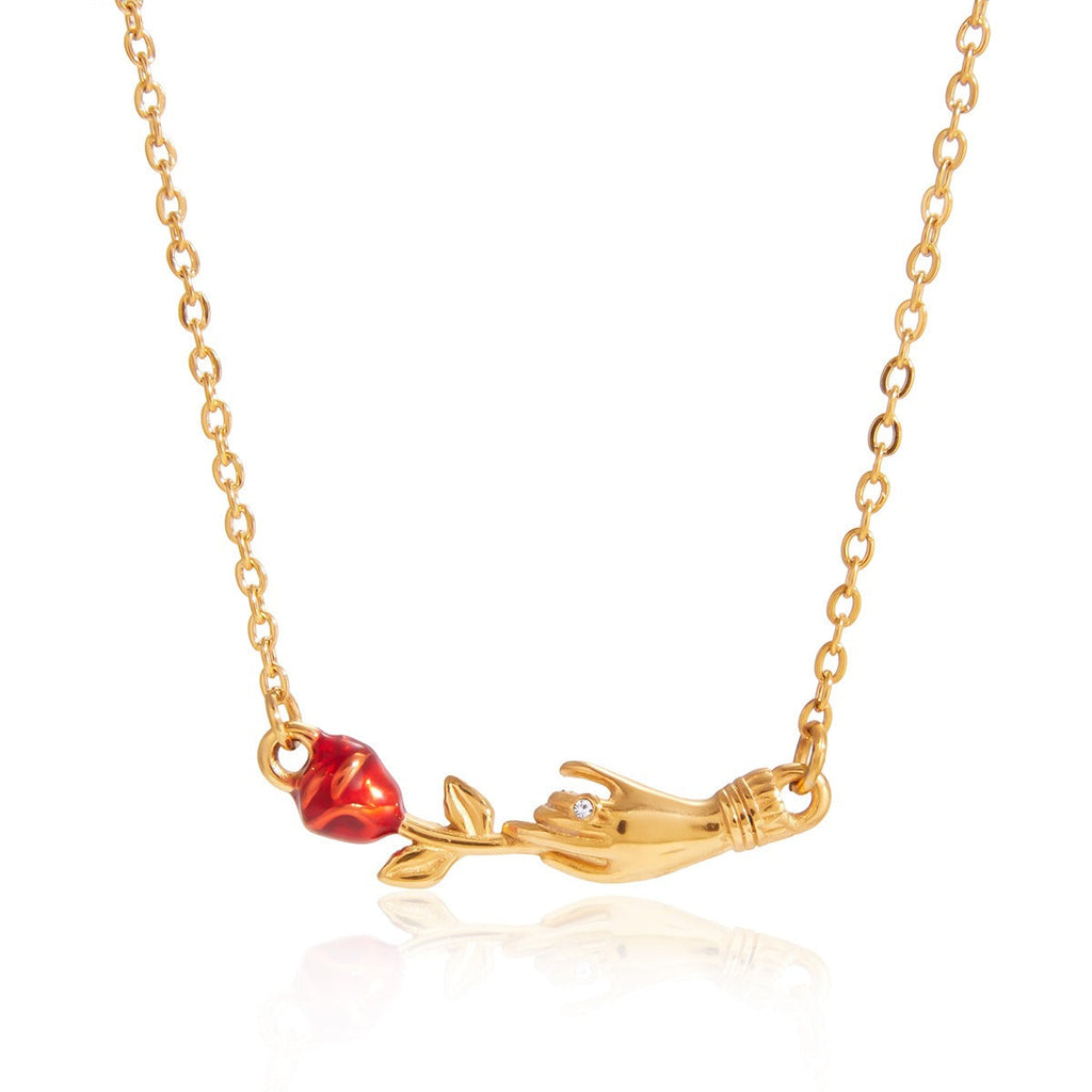 Close-up of an elegant 18K gold rose flower pendant necklace resting on a neutral background.