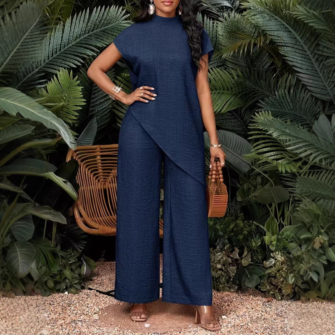 A woman wearing a minimalist asymmetrical sleeveless top and matching pants in a solid color, resort-wear style.