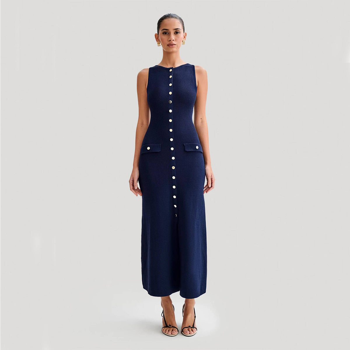 A woman wearing a sleeveless round neck slim-fit knitted dress in Almond color
