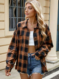 A woman wearing a brown and black plaid long sleeve collared button-down shirt with a white top underneath.
