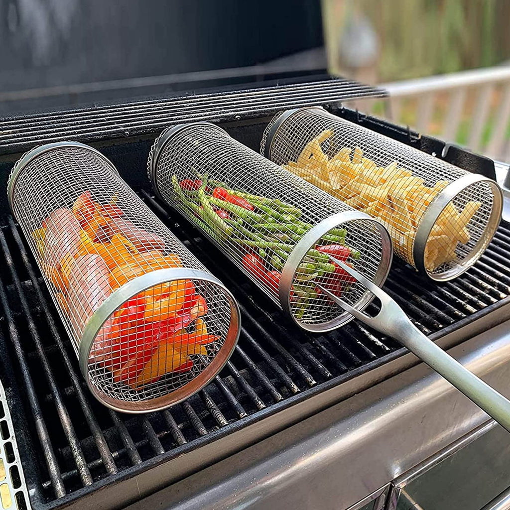 Stainless steel rolling grilling basket on a barbecue grill filled with vegetables