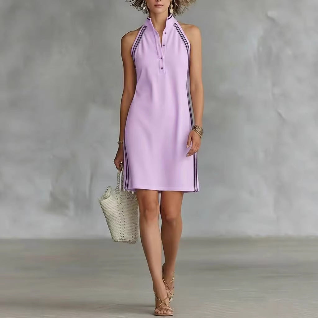 A woman wearing a sleeveless purple polo shirt dress with a button-up collar and side stripes, paired with sandals.