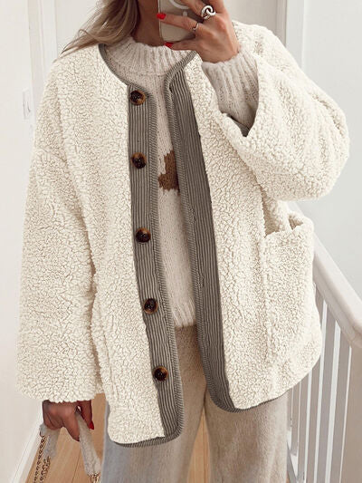 Close up of women's cozy contrast button-up sherpa fleece jacket with pockets