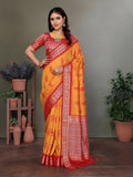 Orange Banarasi silk saree with intricate woven designs and unstitched blouse fabric.