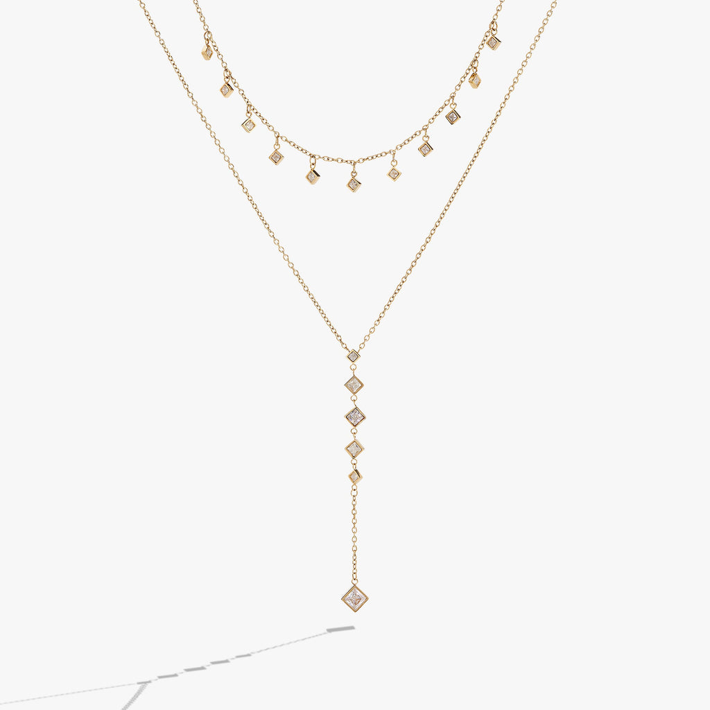 Two-layered necklace featuring princess-cut crystal charms on textured chains.