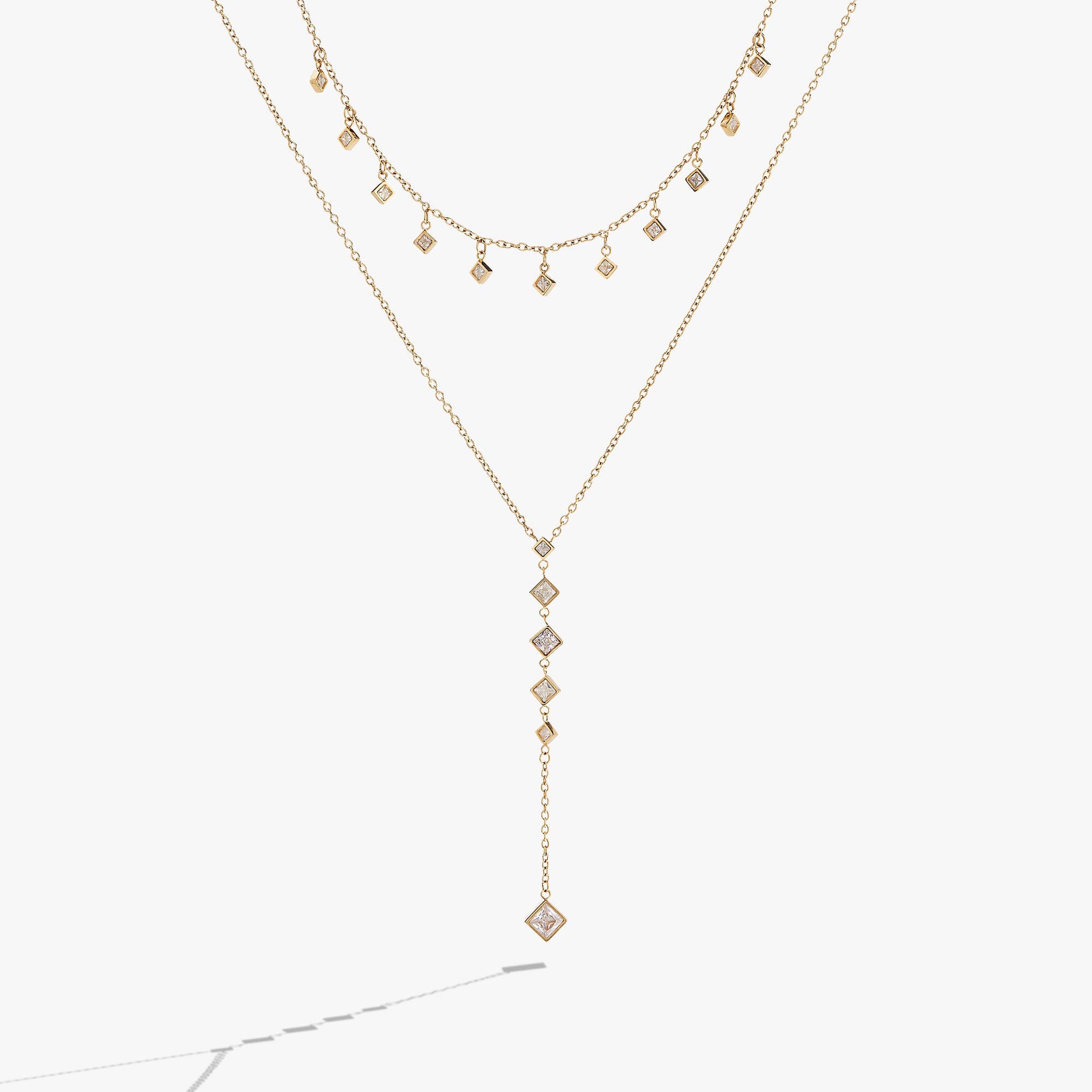 Two-layered necklace featuring princess-cut crystal charms on textured chains.