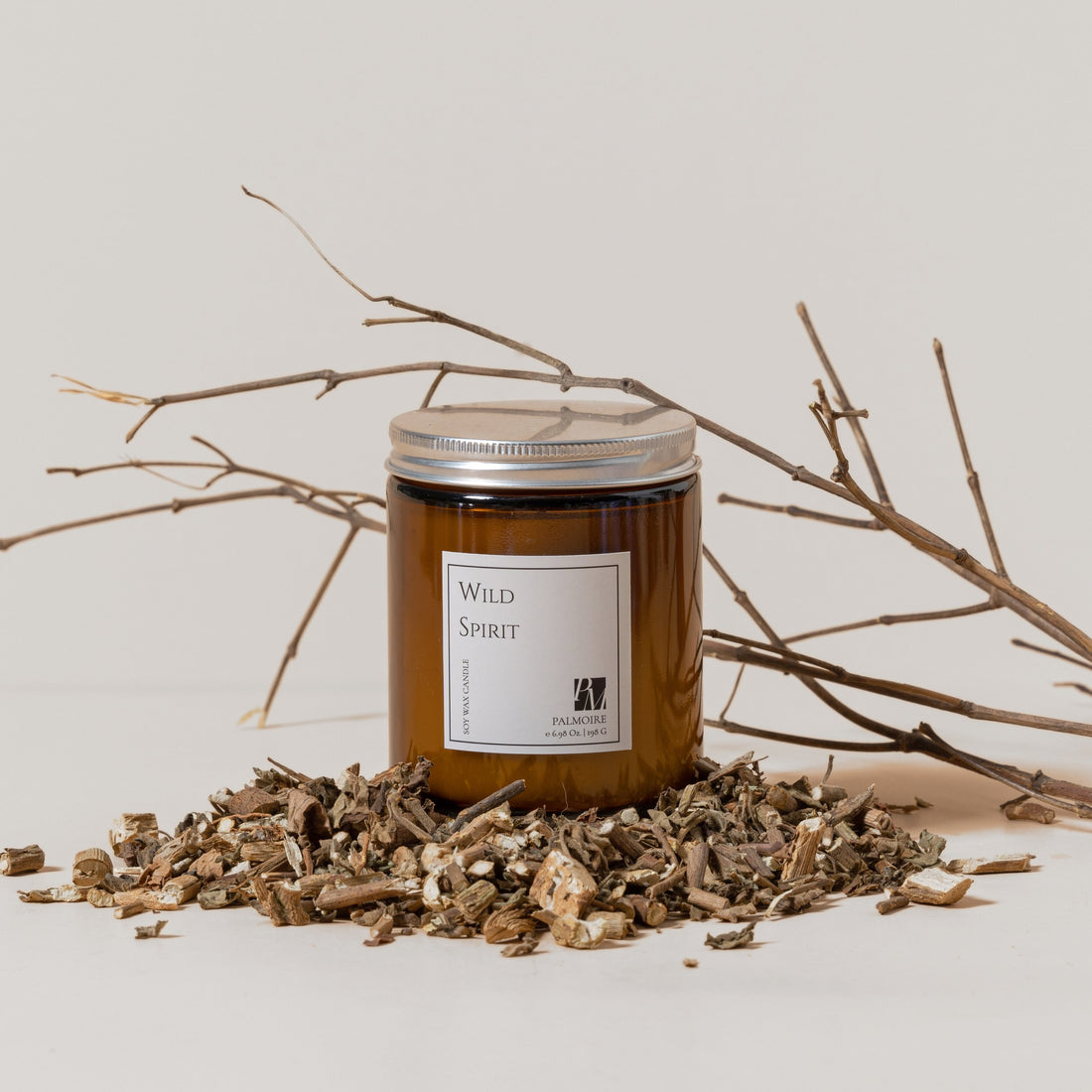 Wild Spirit soy wax candle in an amber glass jar with a metal lid sitting next to a Kraft paper box.