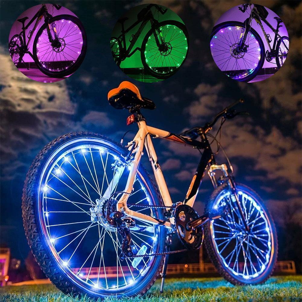 Close up of 20 LED waterproof bike wheel spoke lights glowing on a bicycle wheel at night