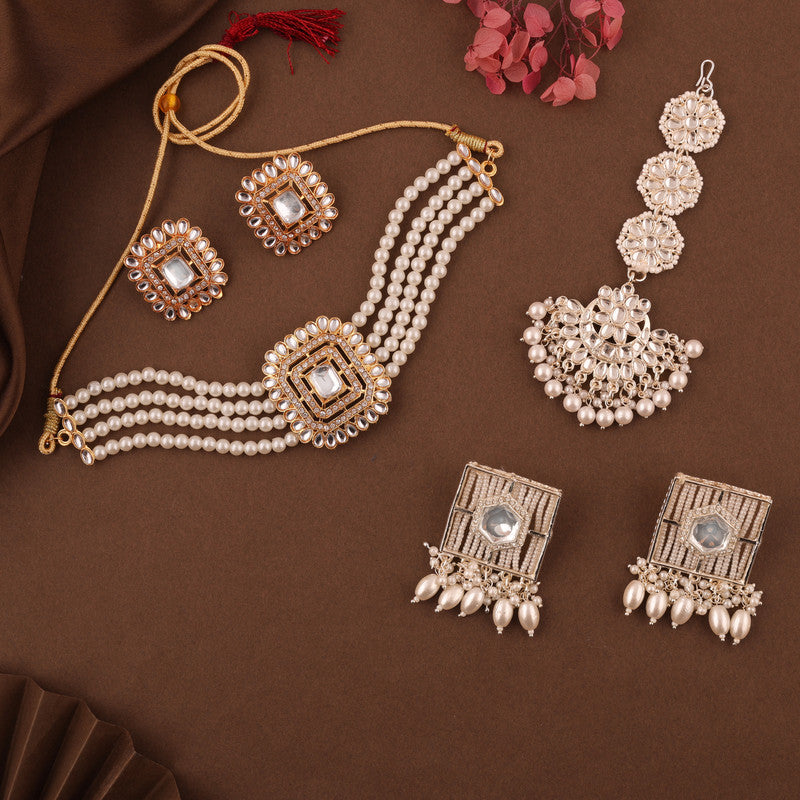 Gold necklace and earring set with Kundan and pearl accents including a maang tikka